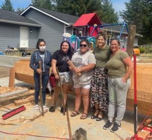 Andrea Wilbur Sigo, and a group of community members in front of a log intended to be used for a welcoming pole in Pioneer Square, Seattle, Washington