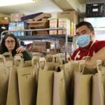 学生和老师在食品银行把食品放在袋子里.